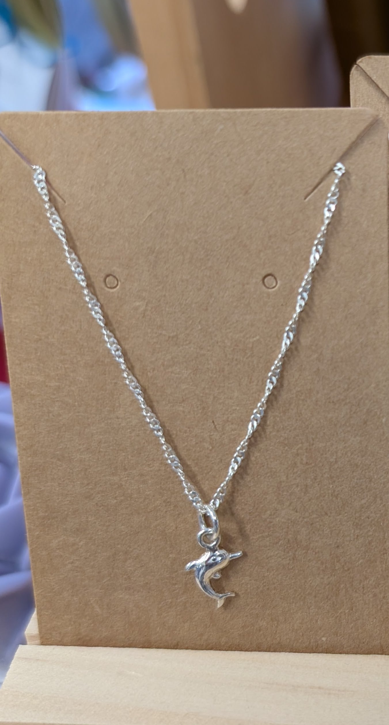 Peruvian Silver 950  gold necklace with a dolphin pendant. Chain is absolutely beautiful. Shown in a display.