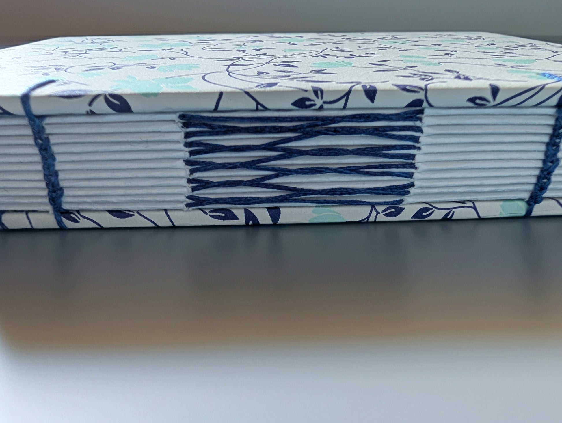 Handmade Coptic Binding Sketchbook, 5x7 with French Stitch. Italian paper for the covers, shown the open spine with stitches.