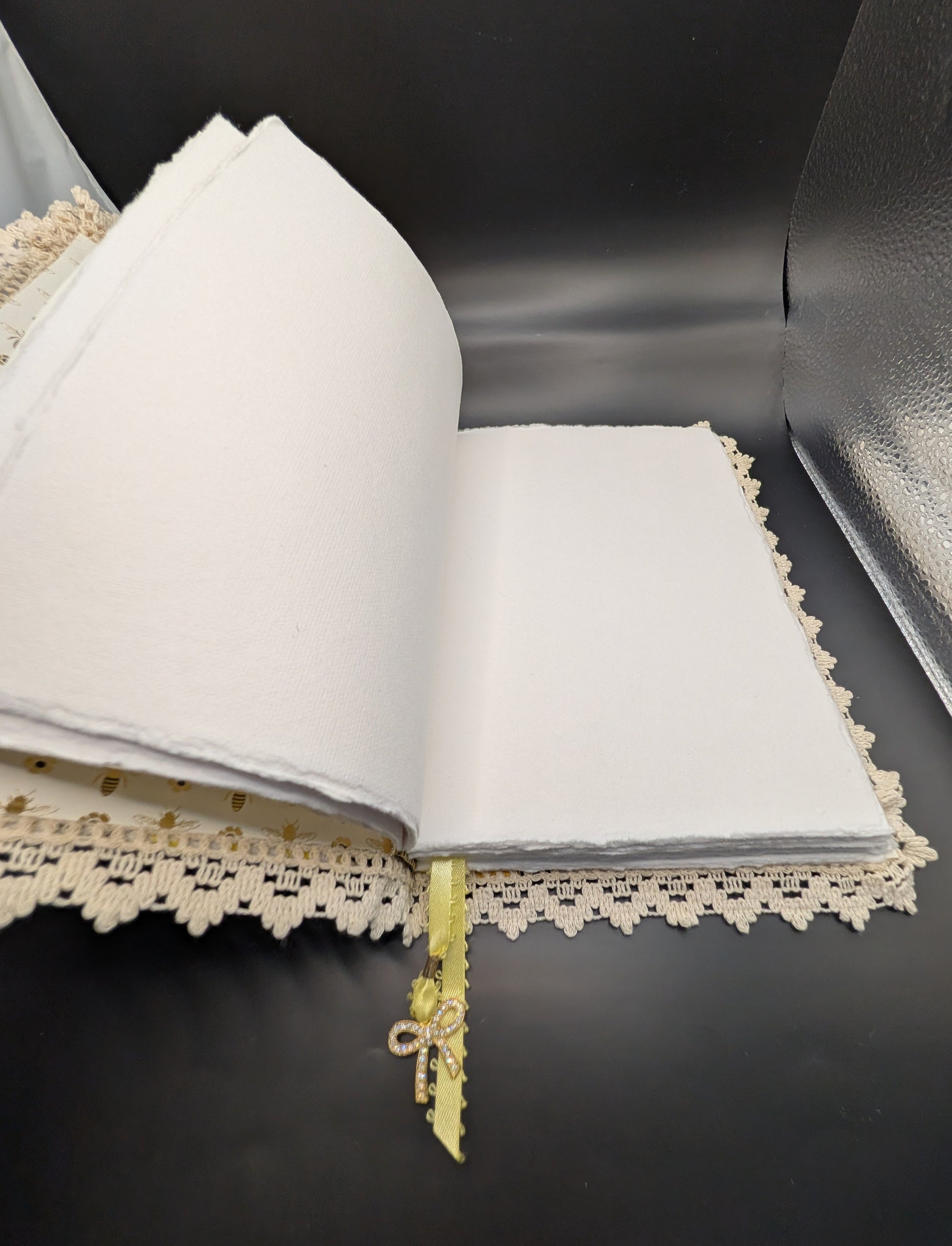Handmade fabric and lace journal with honeybee pattern for journaling and scrapbooking, showing deckle edges paper.