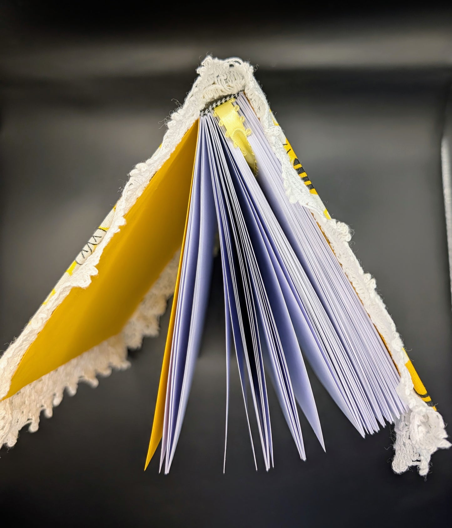 Handmade fabric and lace journal with honeybee pattern for journaling and scrapbooking. Showing the journal standing up, showing the structure.