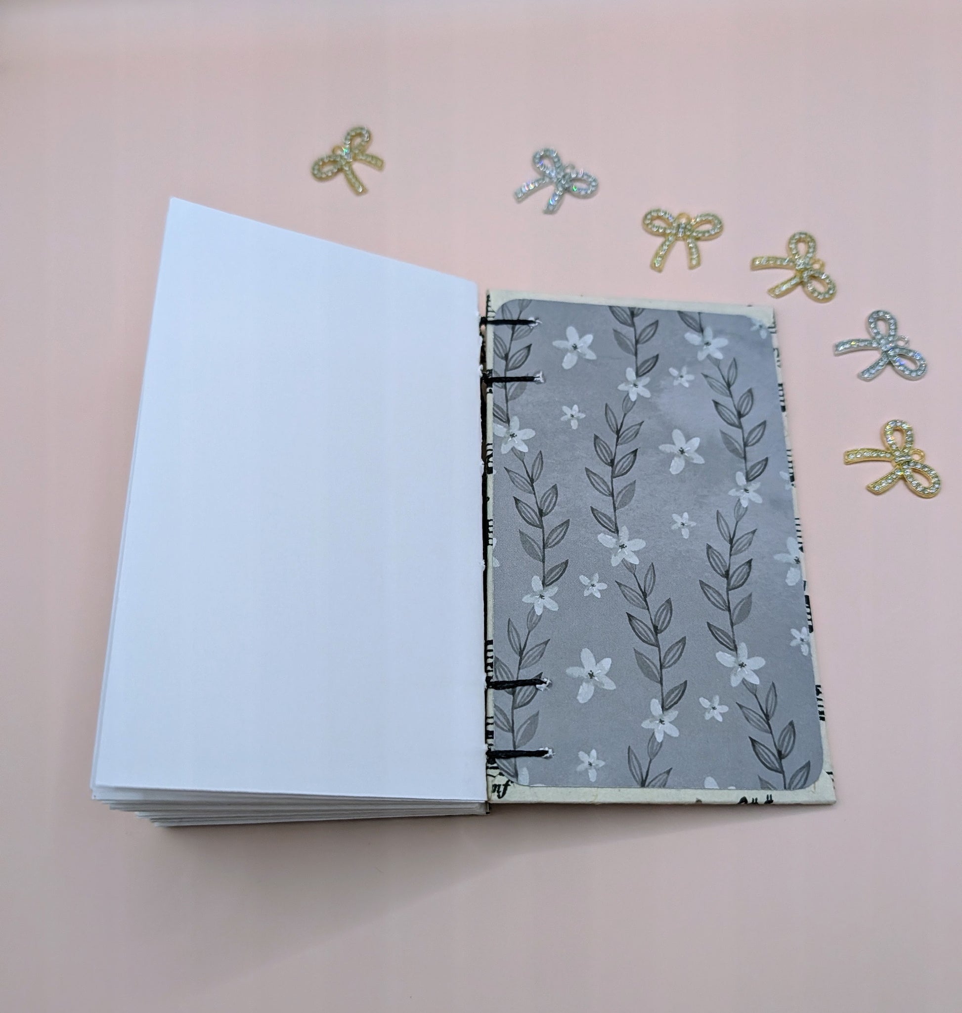 Handmade mini sketchbook featuring purple melody notes pattern on a fine paper from Nepal and a decorative purple French Stitch. Shown sketchbook end paper with fine acid-free scrapbook paper