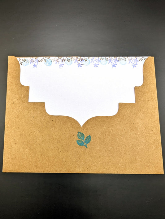 Handmade stationery card with a design resembling an autumn leaf on a brown background, paired with a beige envelope.