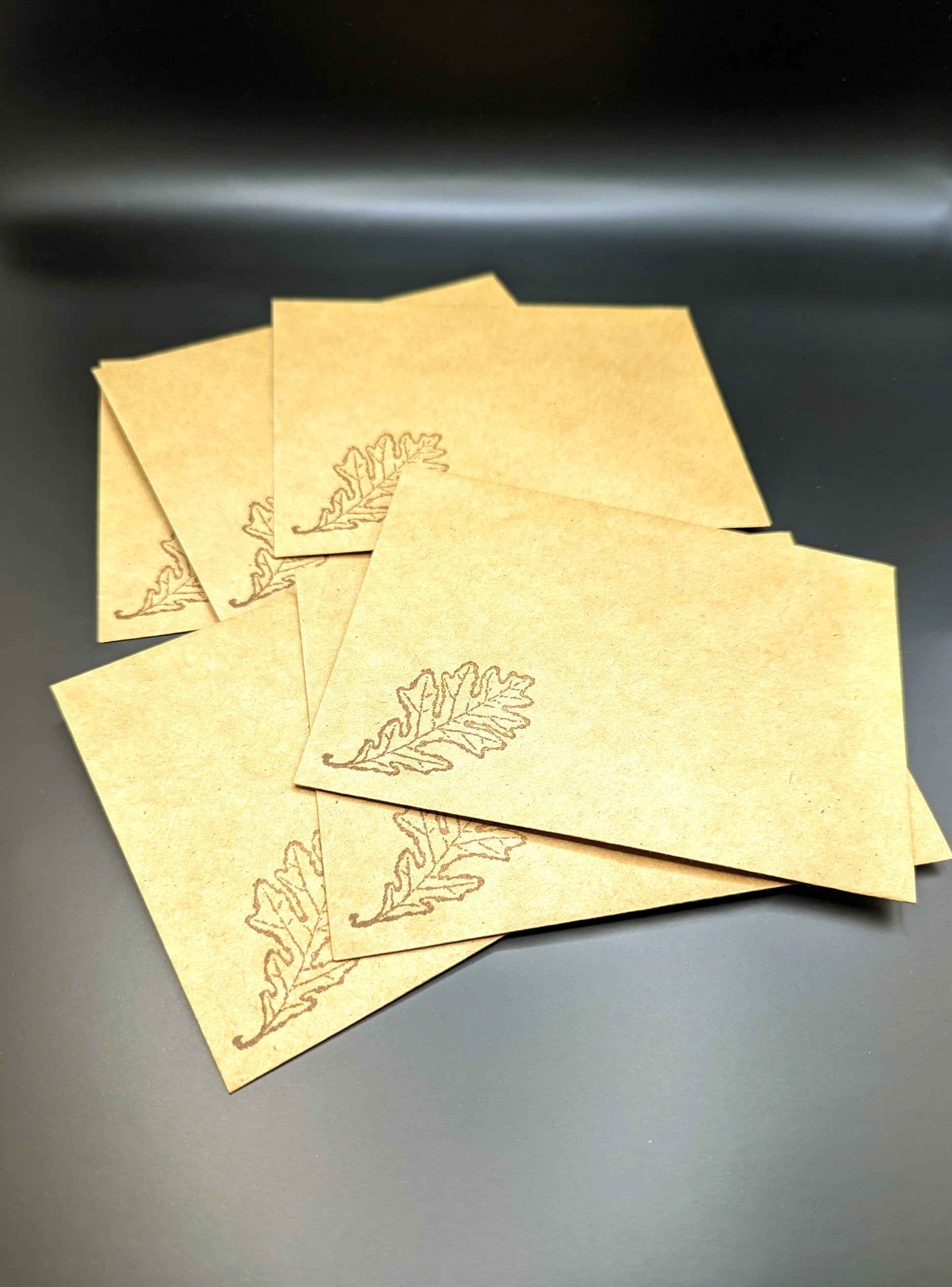 Handmade stationery card with a design resembling an autumn leaf on a brown background, paired with a beige envelope. Showing the envelopes with a beautiful rubber stamped image of a leaf.