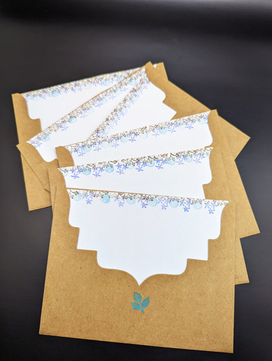 Handmade stationery card with a design resembling an autumn leaf on a brown background, paired with a beige envelope.