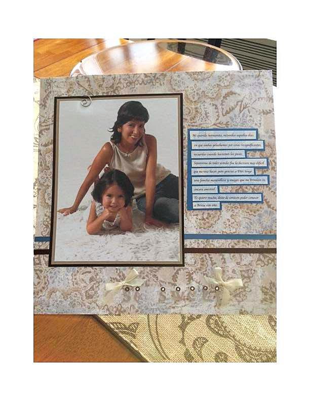 Personalized 12x12 scrapbook page featuring a portrait photo of a mother lying on a rug with her toddler, set against a gold damask paper background with brown matting, delicate ribbon bows, and vertical blue text blocks containing a sentimental note.